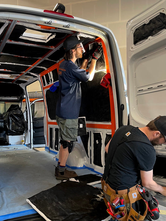 A person in the process of custom installations inside an Adventure Wagon sprinter van 