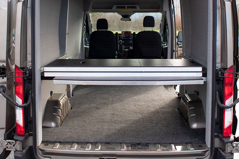 Adjustable camper van bed shown from back of van