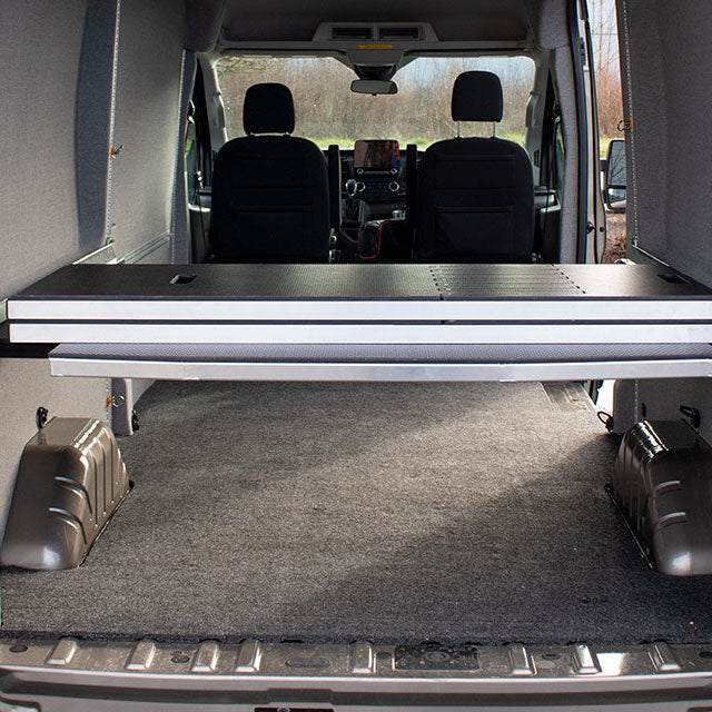 Adjustable camper van bed shown from back of van