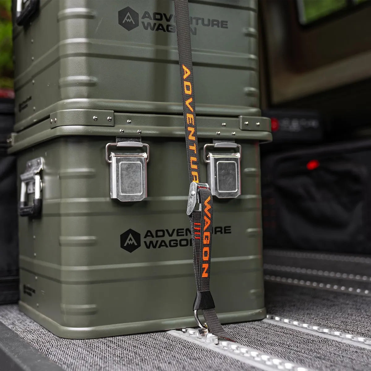 Adventure Wagon AUX storage boxes secured inside a camper van with tie-down straps attached to the modular L-Track floor system.