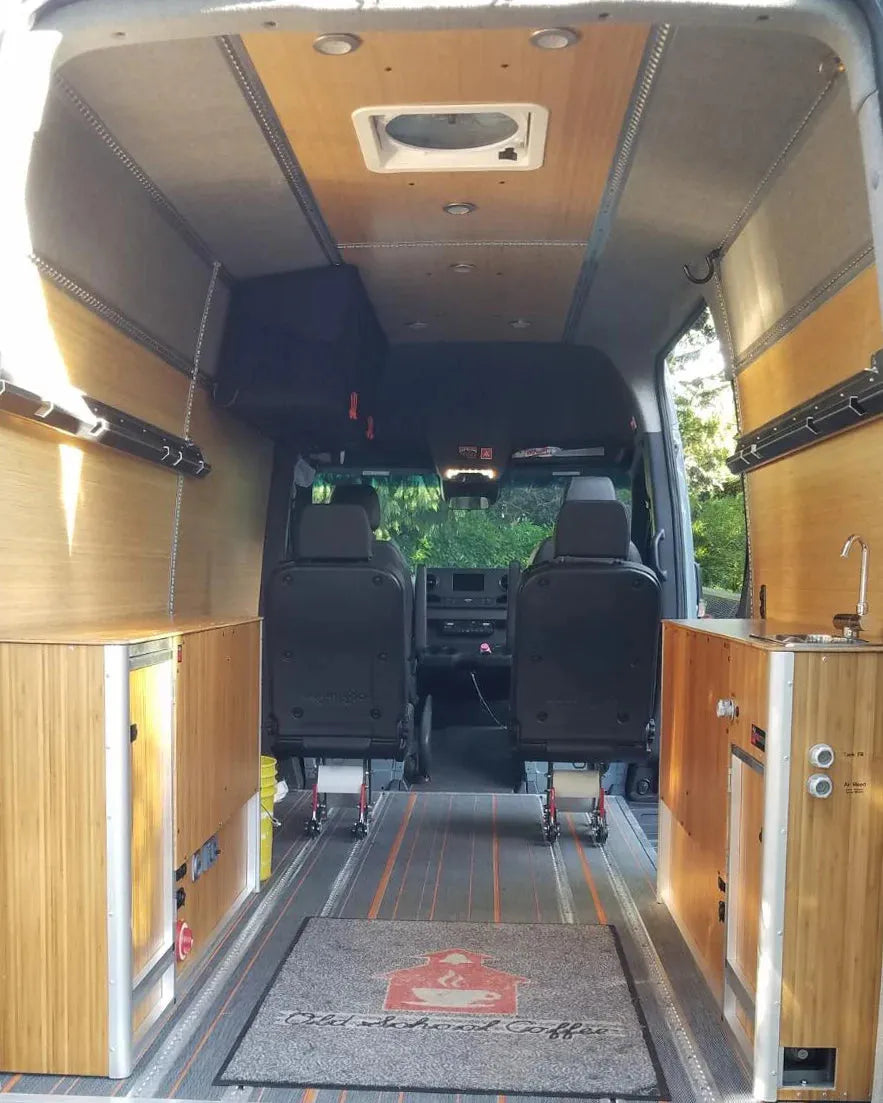 Adventure Wagon camper van interior with bamboo galley cabinetry, sink, storage and modular living space.