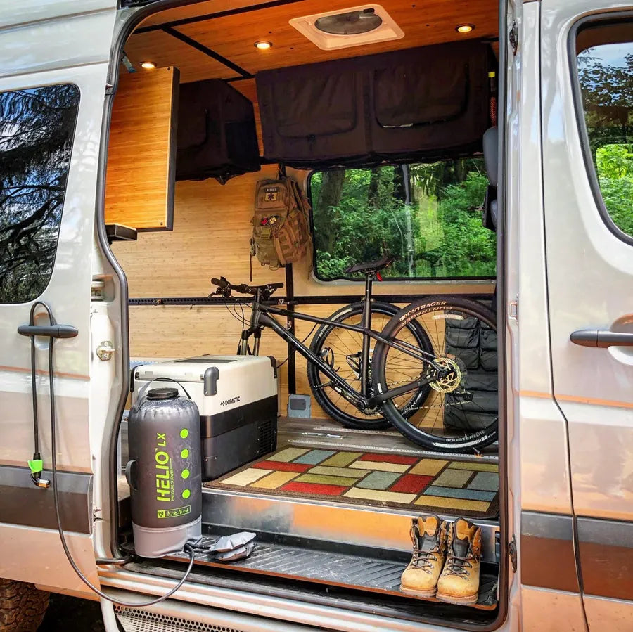 Adventure Wagon camper van interior configured for bike storage with a mountain bike, overhead Mule Bags and flexible open floor space.