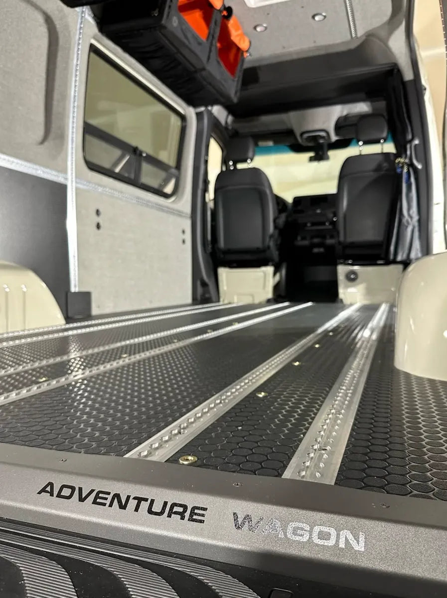 Adventure Wagon camper van floor with multiple integrated L-Track rails for securely mounting seats, storage, gear, and modular accessories.