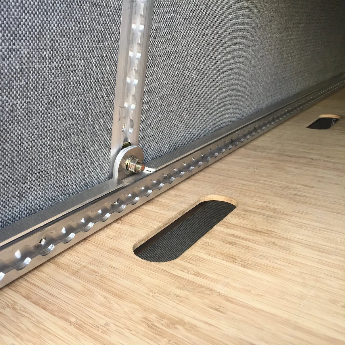 Adventure Wagon camper van interior L-Track detail showing a floor-mounted aluminum cargo track for securing gear and modular accessories.