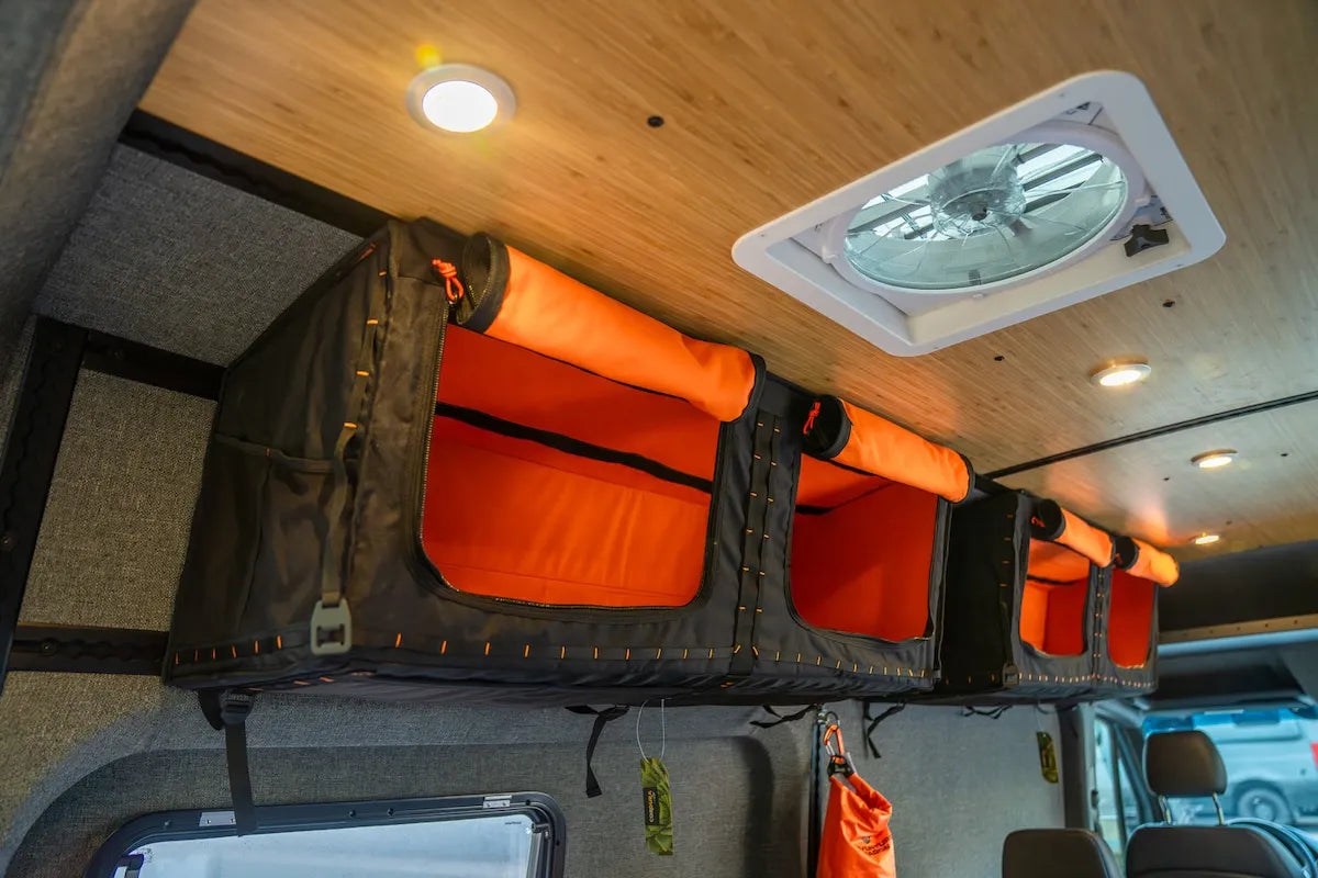 Adventure Wagon overhead Mule Bags installed along the upper camper van wall for flexible soft-sided gear and clothing storage.