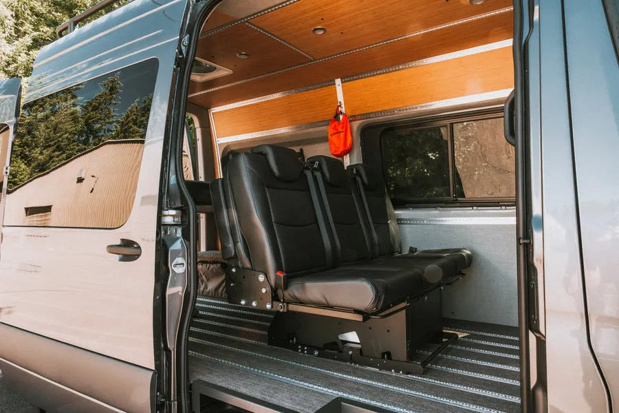 Adventure Wagon camper van interior with modular bench seating, bamboo wall panels and flexible L-track floor system.