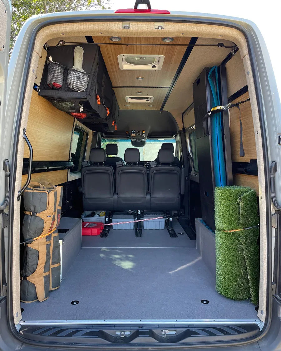 Adventure Wagon camper van interior configured with passenger seating and open space for gear storage.