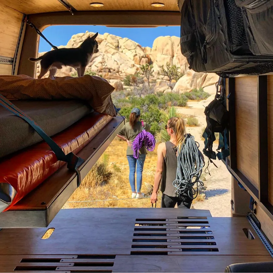 Adventure Wagon camper van interior loaded with rock climbing gear, ropes and modular bed platform for an outdoor climbing trip.