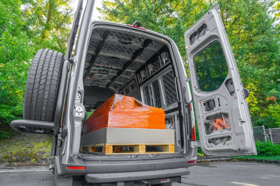 Packaged Adventure Wagon Interior System components loaded into the rear of a Mercedes-Benz Sprinter van before DIY Install.