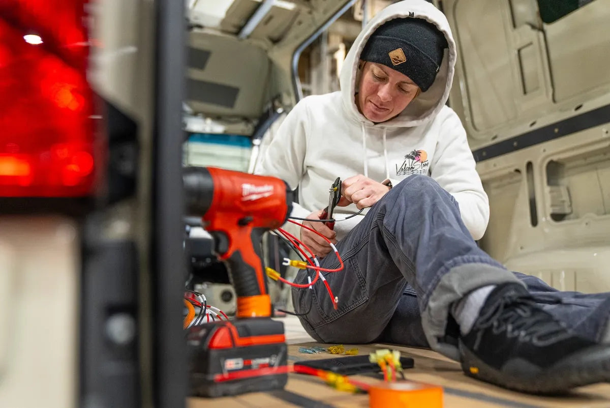 Adventure Wagon installer connecting and organizing camper van electrical wiring during a professional Factory Install.