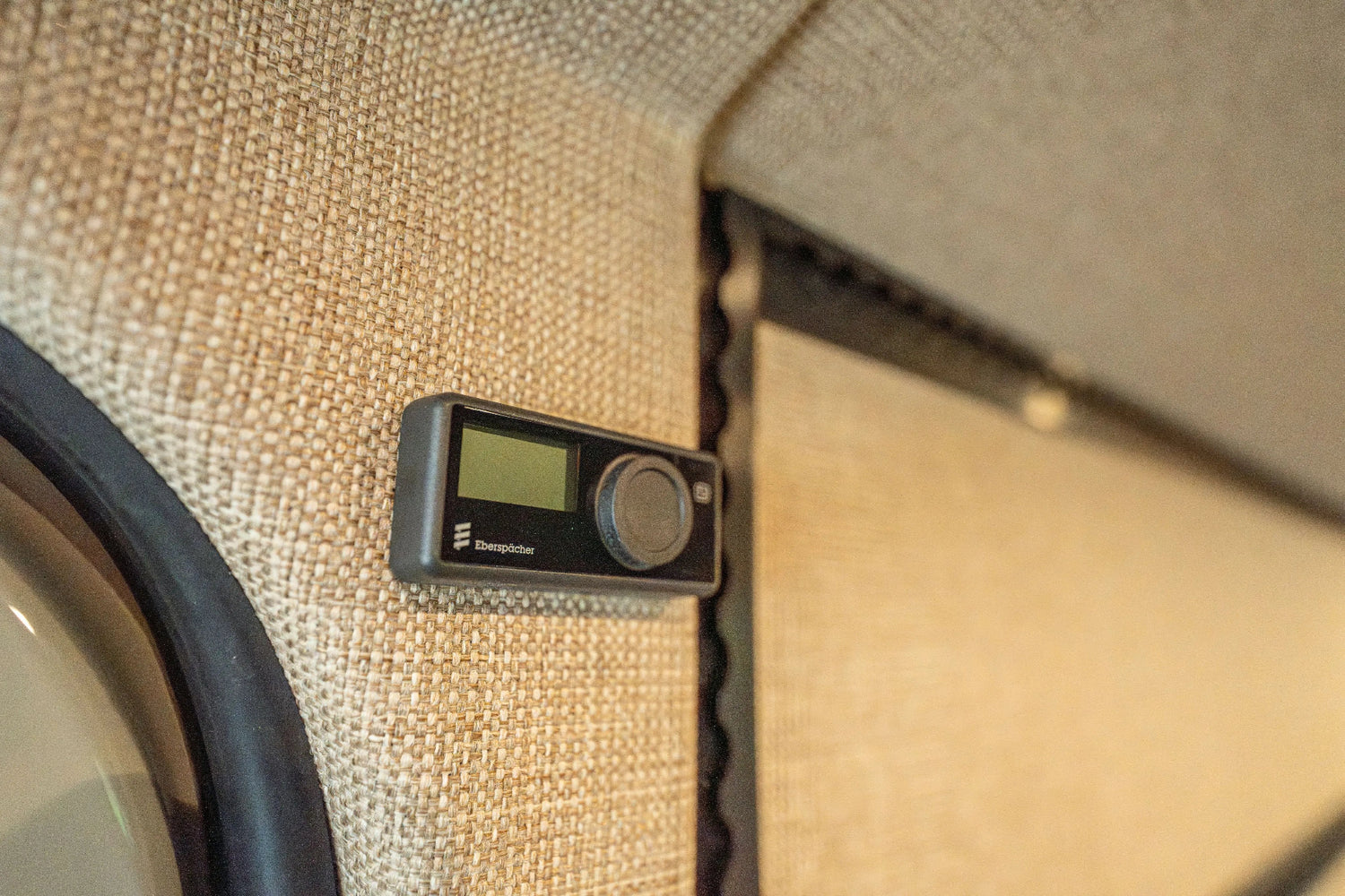 Adventure Wagon Guided Build 538 heater control mounted on the upholstered interior wall of the Sprinter camper van.