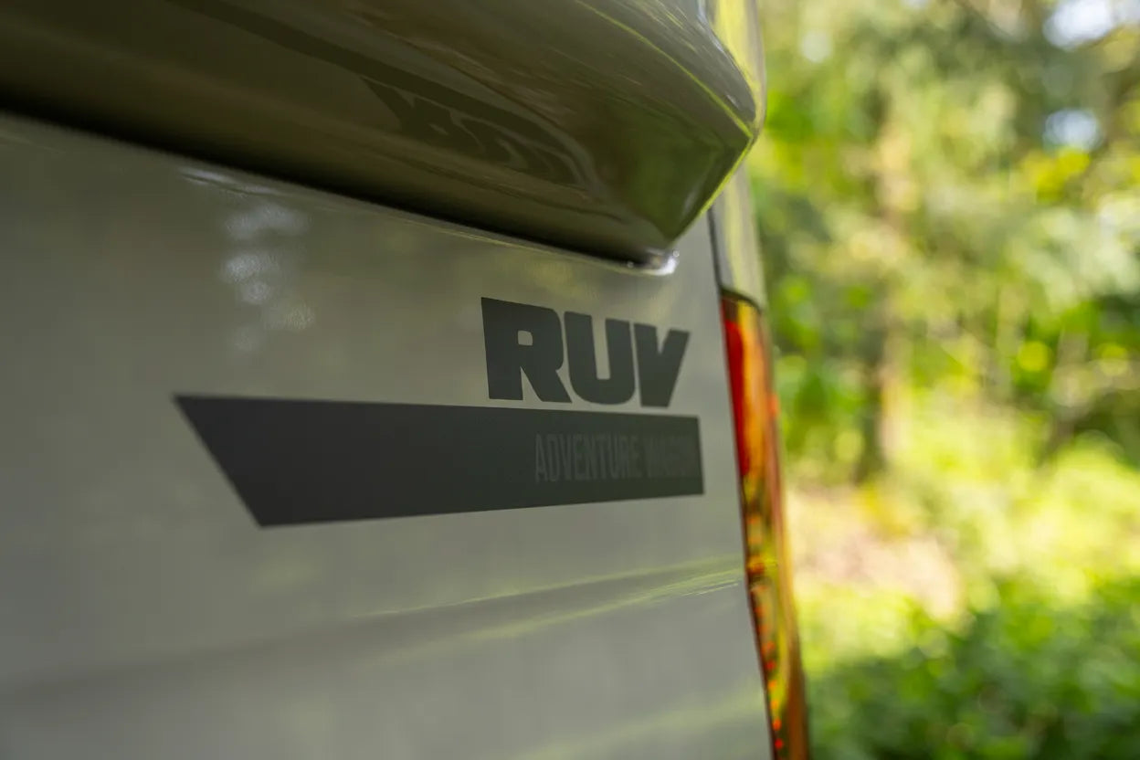 Adventure Wagon Guided Build 715 RUV exterior logo detail on the rear side of the Mercedes Sprinter camper van.