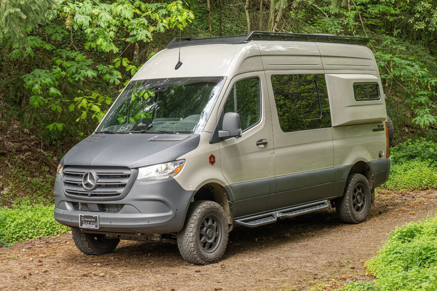 Adventure Wagon Guided Build 538 Mercedes Sprinter front exterior parked in a wooded setting.