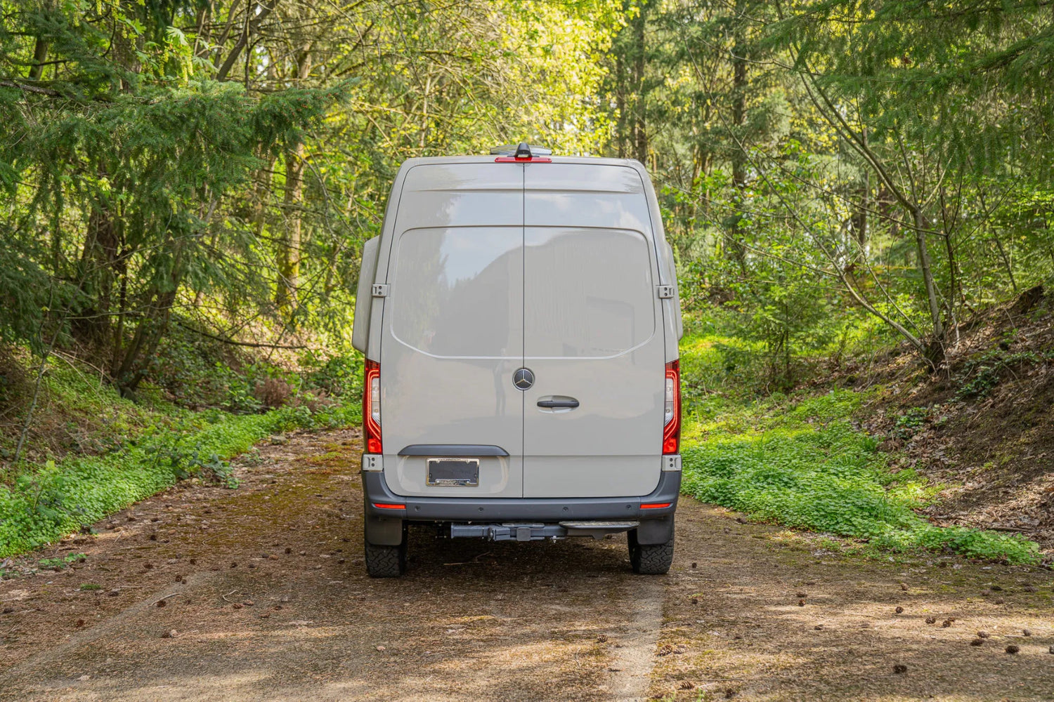 Adventure Wagon Guided Build 715 Mercedes Sprinter rear exterior parked in a forest.