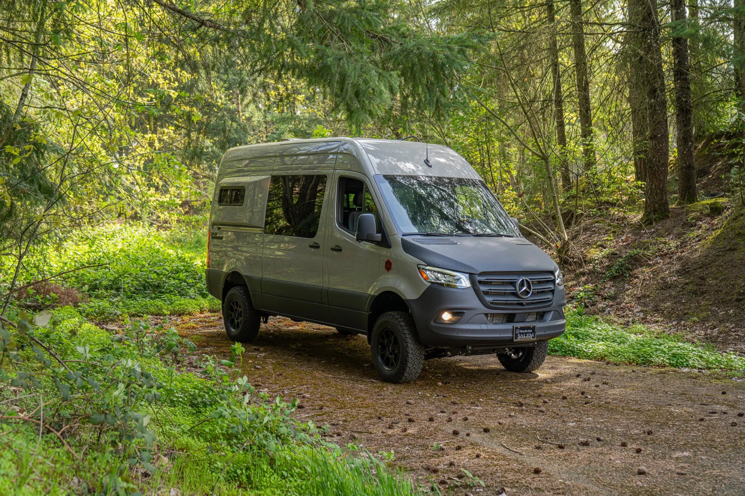 Adventure Wagon Guided Build 715 Mercedes Sprinter front three-quarter exterior parked on a forest road.