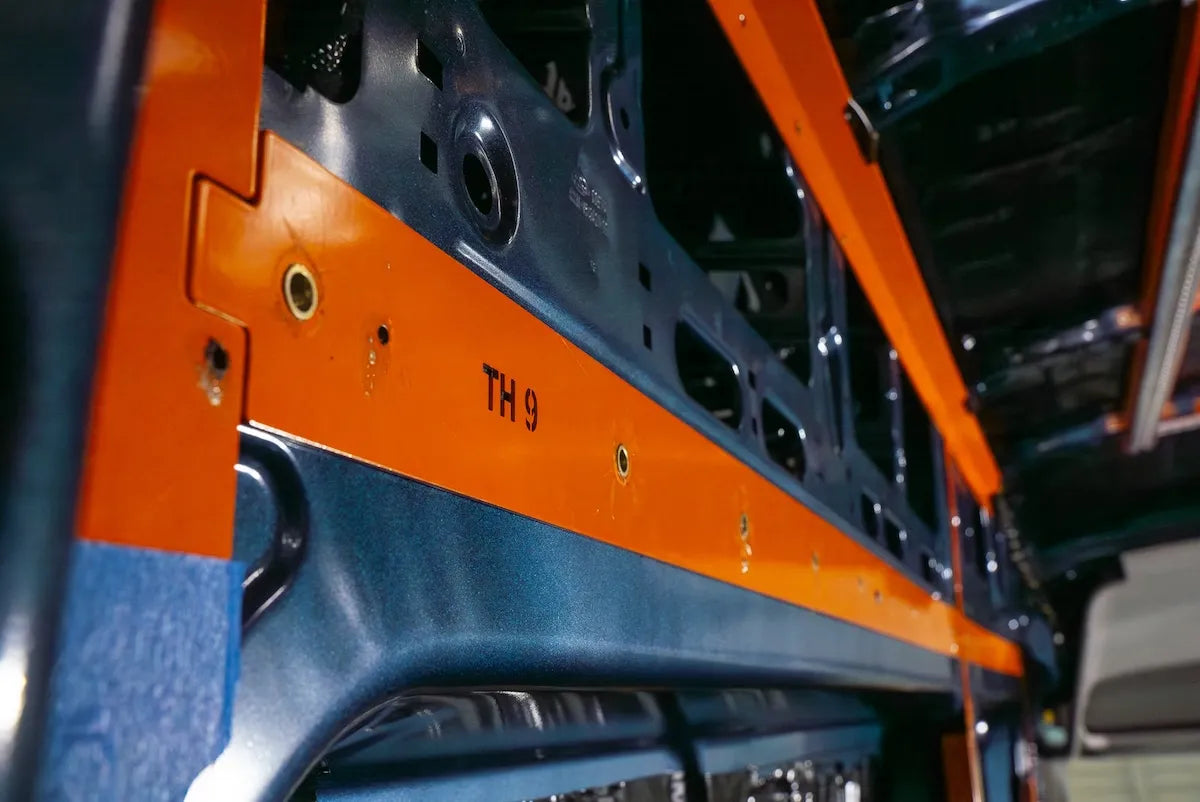 Close-up of the orange Adventure Wagon Interior System A-Frame mounted to the camper van body during the Factory Install process.