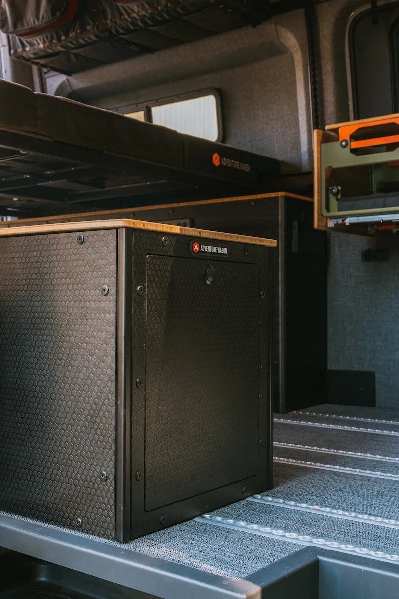 Close-up of Adventure Wagon modular Switchback Storage Box with bamboo countertop beneath the raised bed platform and adjacent Switchback Galley components.
