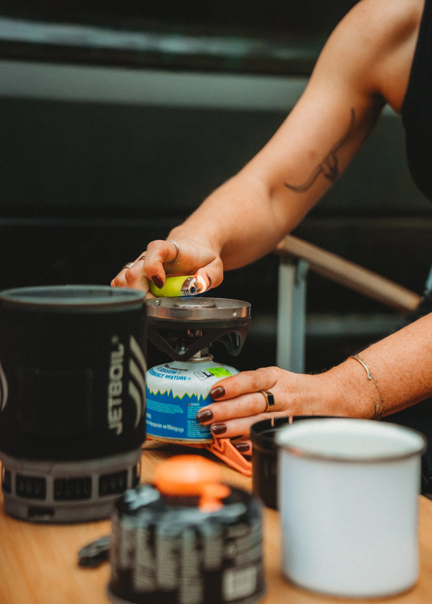 Solo traveler lighting a camp stove to make coffee beside the Adventure Wagon Solo Nomad van.