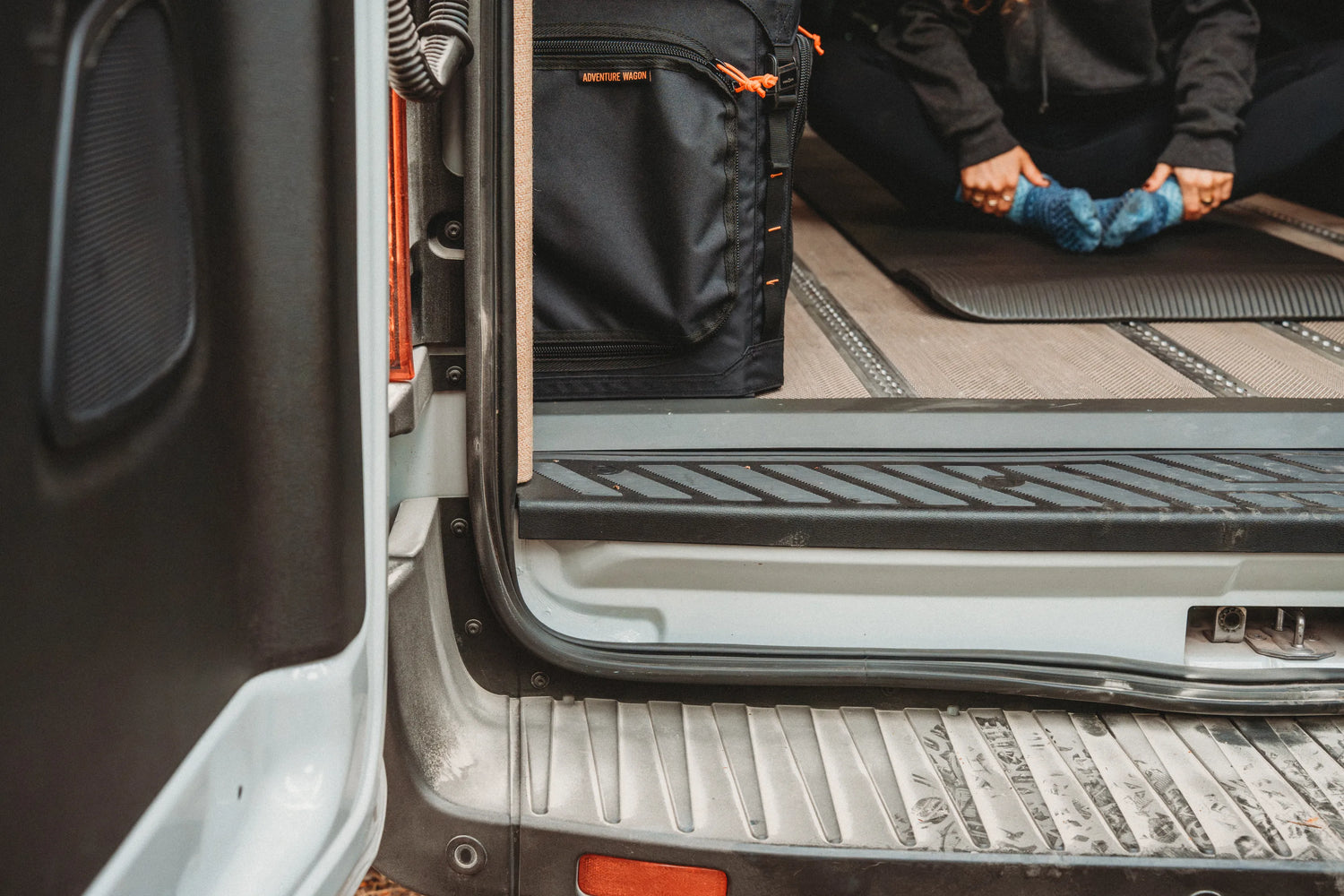 Solo traveler stretching on a yoga mat inside the Adventure Wagon Solo Nomad camper van.