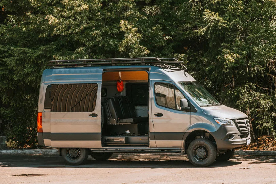Adventure Wagon Mercedes Sprinter camper van with side door open, showing modular interior storage and camping equipment.