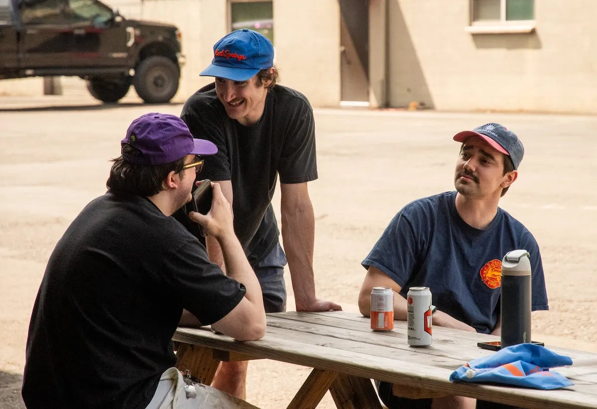 Adventure Wagon team members talking and relaxing around a picnic table during a company gathering outside the shop.