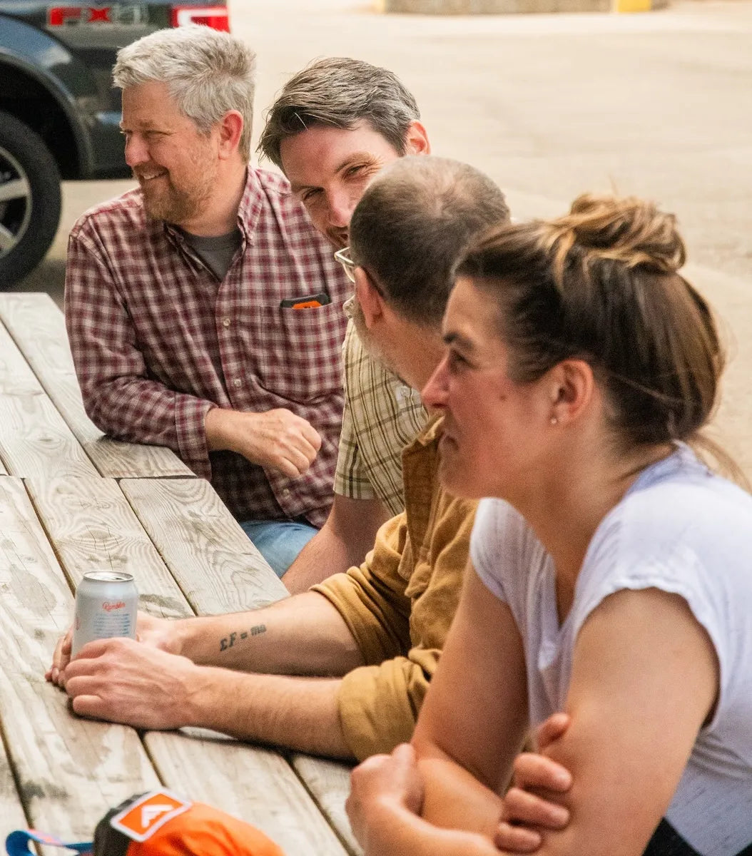 Adventure Wagon team members gathered around a picnic table during a company barbecue outside the Portland shop.